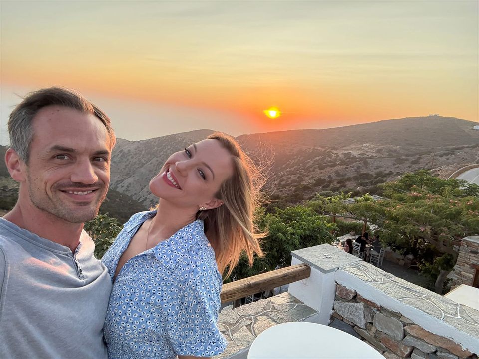 Taylor and his wife at sunset over island hills in Greece.
